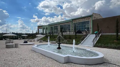 Prédio metálico finalizado com praça e fonte frontal