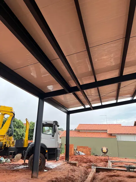 Cobertura metálica instalada com caminhão e escavação no canteiro
