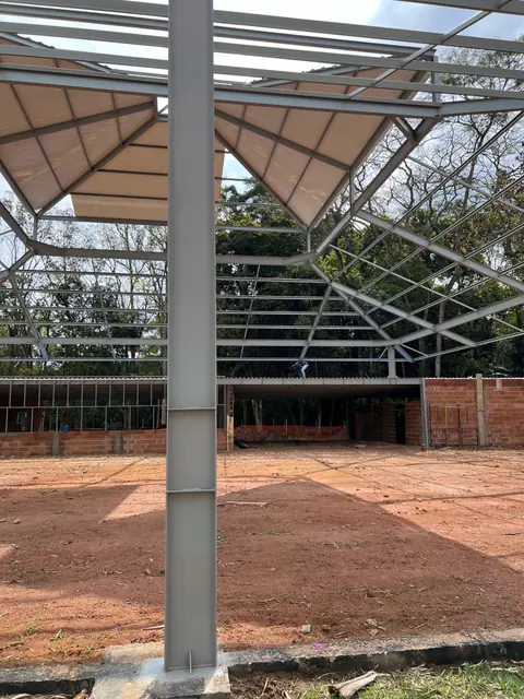 Estrutura metálica com cobertura em instalação sobre base de alvenaria