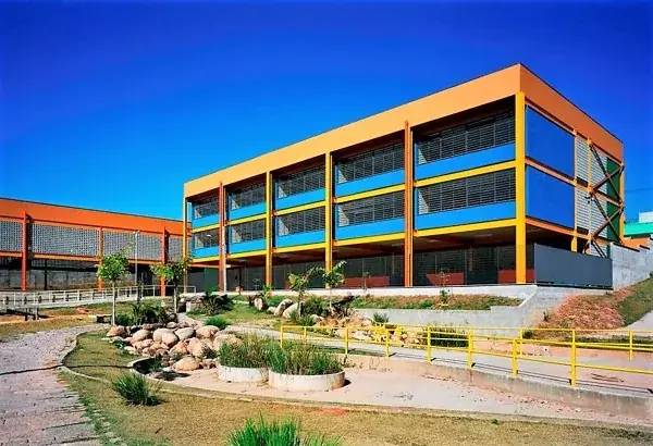Edifício comercial de três pavimentos com estrutura aparente laranja