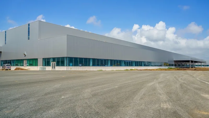Fachada externa de galpão industrial com fechamento branco e detalhes azuis