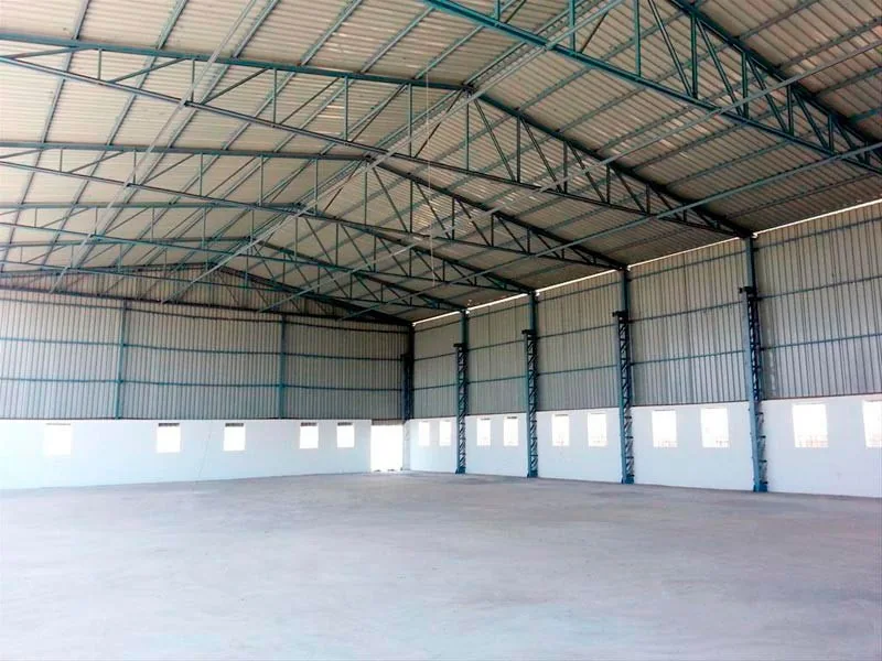 Interior de galpão amplo com cobertura metálica em arco