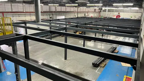Estrutura metálica em montagem dentro de galpão industrial