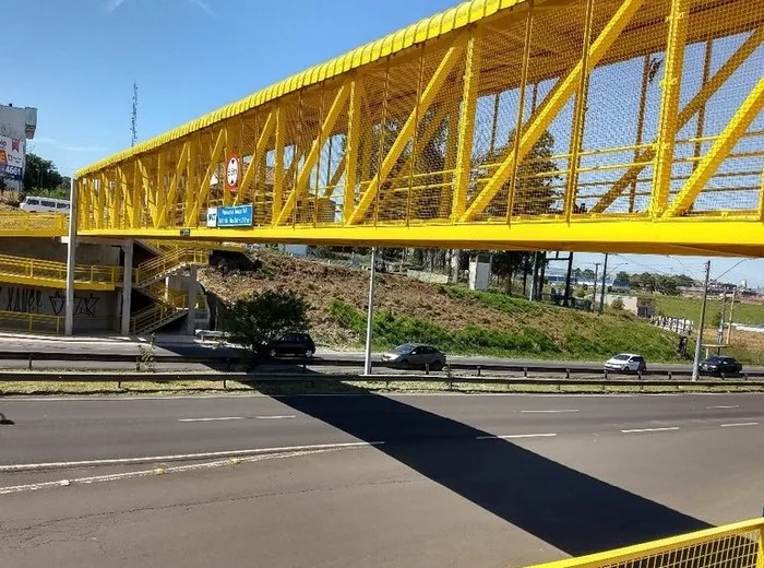 Passarela elevada de pedestres com estrutura metálica amarela
